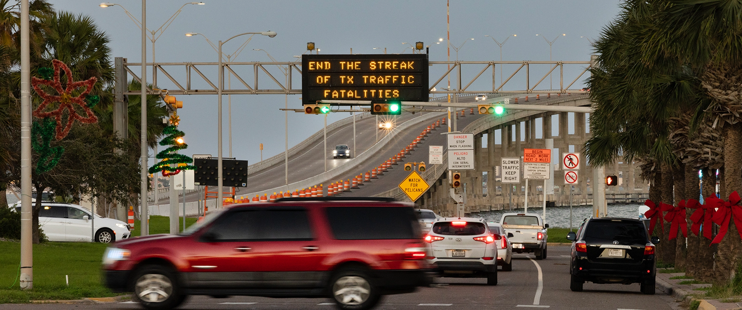 Voluntarios con chalecos de seguridad recogiendo basura al costado de la carretera