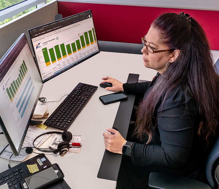 Trabajador en el escritorio mirando gráficos en el monitor de la computadora