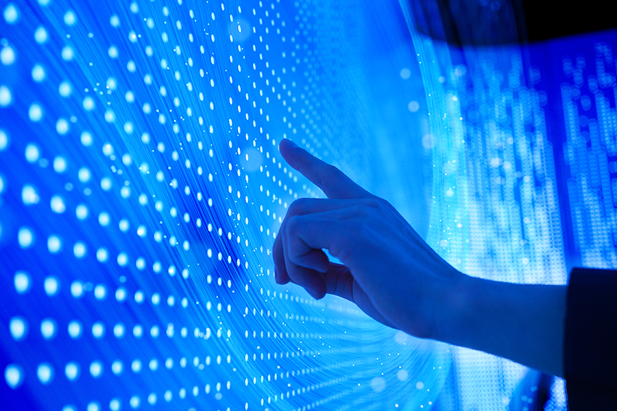 A human hand touching blue light points.