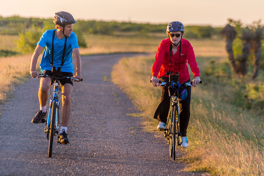 two cyclists ride on paved road