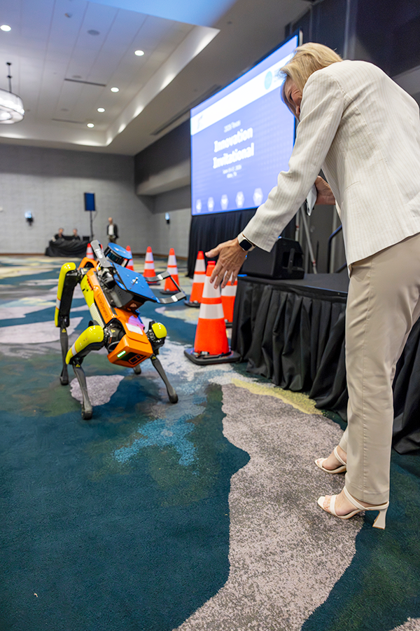 Emcee, Shelley Row, engaging with TxDOT’s robot dog, Spot, during the 2026 Texas Innovation Invitational in Allen, Texas June 15-17, 2026.