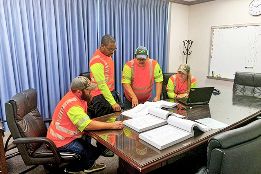 Los empleados de TxDOT discuten las acciones de seguimiento en el puente.