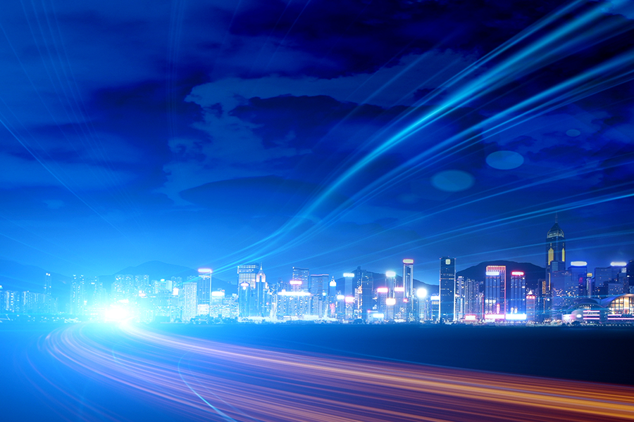 Toma de larga exposición del tráfico por la noche, que aparece como líneas brillantes que conducen hacia un horizonte de la ciudad iluminado