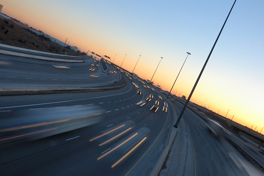 Highway traffic with motion-blurred lights in the late afternoon.