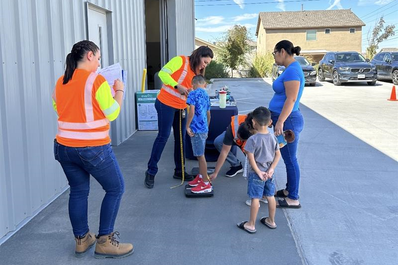 Car seat event Children being weighed at a car seat event by TxDOT workers.