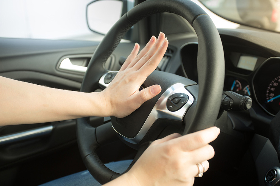 Driver with hand on car horn