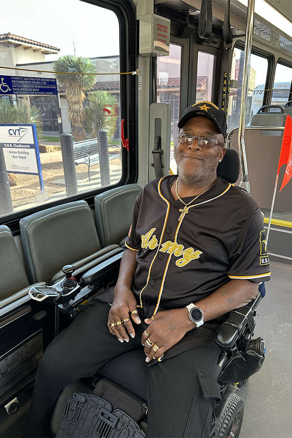 Bus rider in wheelchair A man in an assistive wheelchair smiles as he rides a public bus.