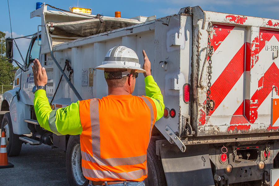 Man in PPE backs up truck