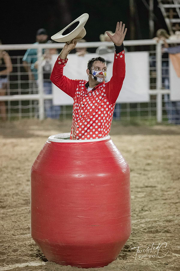 Kody Gray rodeo clown in rodeo barrell, waving cowboy hat.