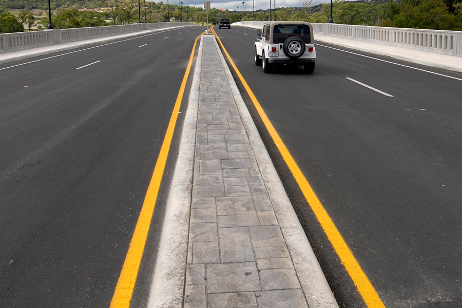 painted median on bridge with vehicles crossing