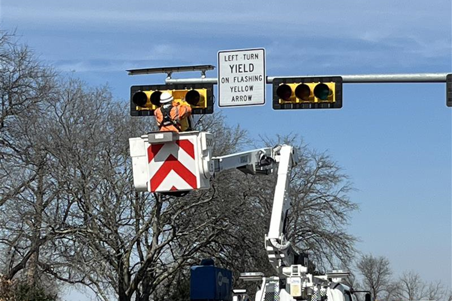 Signal repair crew replaces an overhead traffic light using a bucket truck