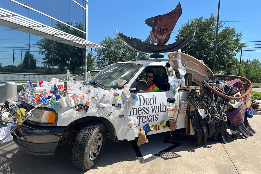 Trash truck "Don't Mess with Texas" truck with trash attached to vehicle.
