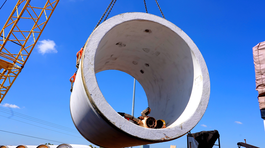 Crane steers pipe before lowering it down