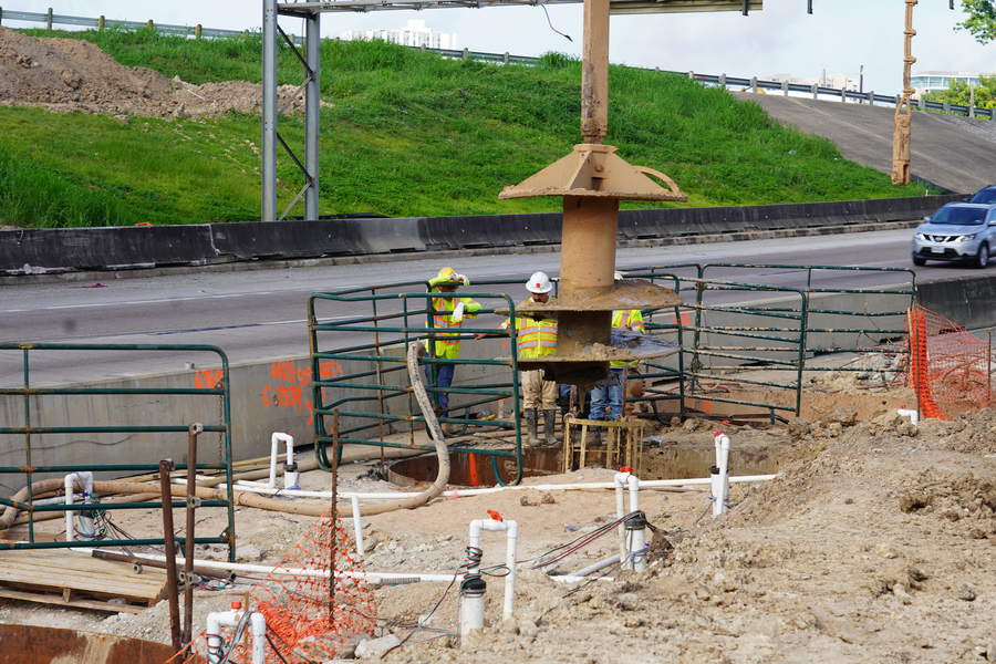 Crews observe the drill bit, known as an auger, as it comes out of the ground