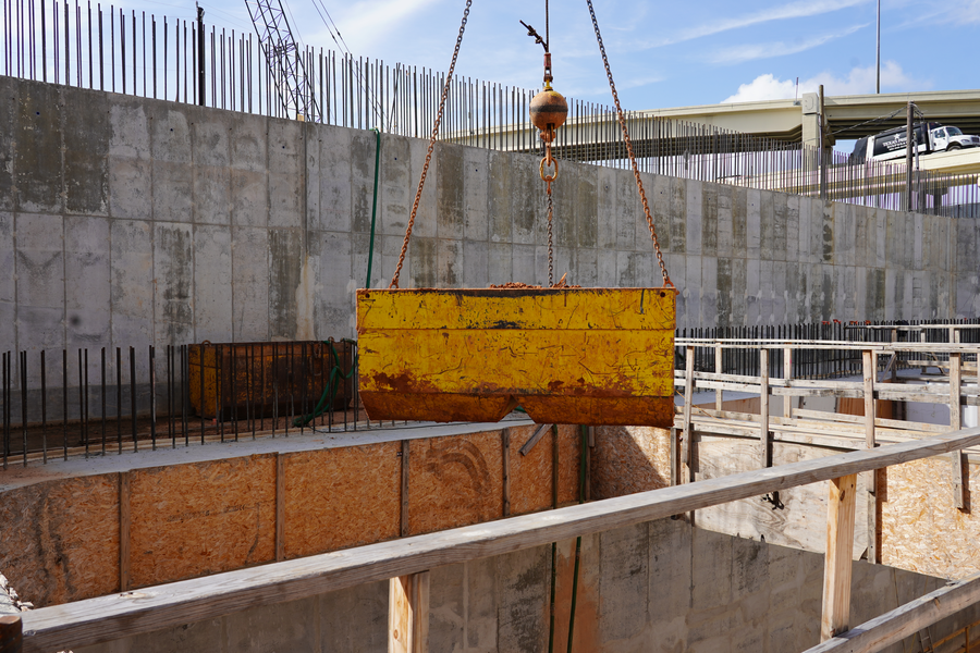 A container of soil is removed from what will be a pump station when finished, which will store and move stormwater during heavy rain events