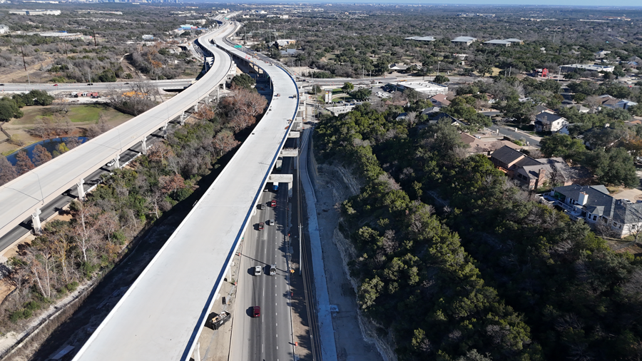 View of new eastbound and westbound US 290 mainlane bridges from above, looking east toward William Cannon Drive, with completed bridge decks as part of the Oak Hill Parkway project.