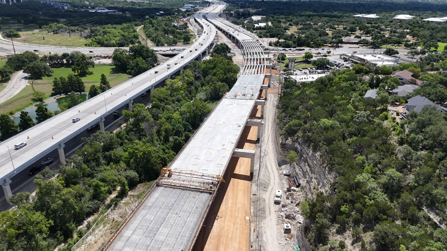 Oak Hill Parkway crews continue construction of the future eastbound US 290 mainlane bridge between Old Bee Caves Road and William Cannon Drive.  Below the bridge, crews are performing grading operations for the future eastbound US 290 frontage road and adjacent shared-use path. July 2025